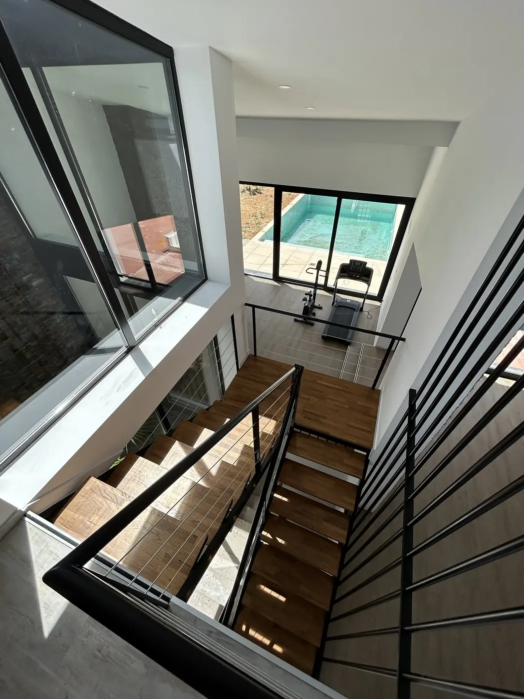 Escalera vista desde arriba con la piscina al fondo