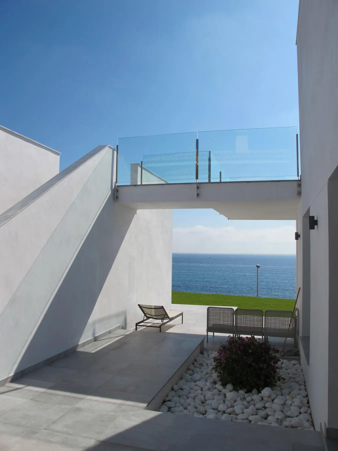 Patio de acceso con el puente de la terraza y el mar